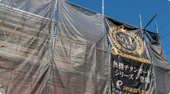 足場に掲げられたPAINT LINE塗料施工の垂れ幕