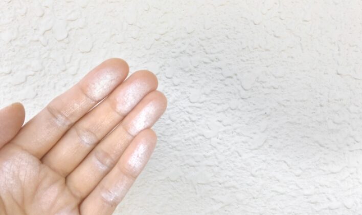 外壁を触り、手に白い粉が付いている